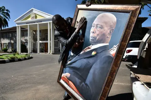 AFP A man holding a portrait of the late former President of Kenya, Daniel arap Moi
