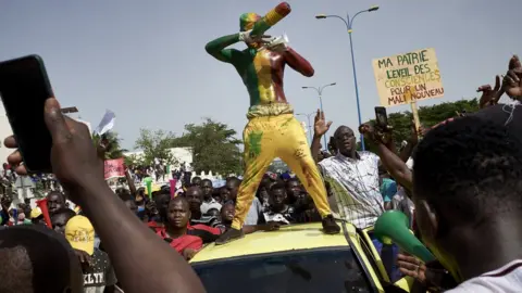 Getty Images A man painted in the colours of Malian flag gestures at Independance square as protesters gather to demand that Malian President Ibrahim Boubacar Keïta leaves office in Bamako on June 19, 2020