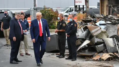 AFP via Getty Images President Donald Trump, Attorney General William Barr and Acting Homeland Security Secretary Chad Wolf tour an area affected by civil unrest in Kenosha