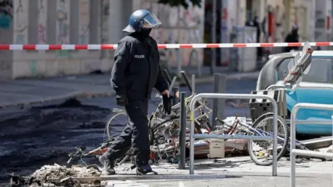 Reuters A police officer walks past extinguished barricades