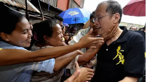 Getty Images Senator Benigno Aquino (R), known as "Noynoy", the son of the late Philippine democracy icon Corazon Aquino, is greeted by residents in the poor district of Baseco in Manila on 12 September 2009.