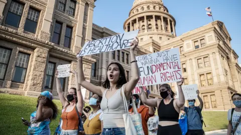 Getty Images Women march and hold placards outside the Texas State Capitol building