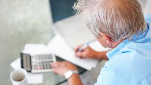 Getty Images Pensioner with calculator