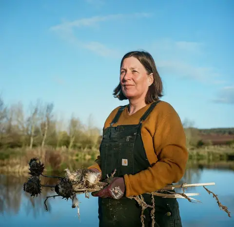 Joanne Coates Flower farmer Paula next to a riverbank