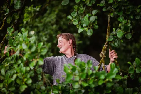 Joanne Coates Farmer Fransje stands amongst greenery
