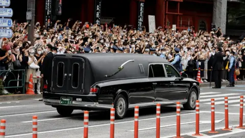Reuters A vehicle carrying the body of the late former Japanese Prime Minister Shinzo Abe, who was shot while campaigning for a parliamentary election, leaves after his funeral at Zojoji Temple in Tokyo, Japan July 12, 2022.