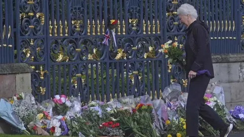 Mark Marlow Lady Mary Peters laying flowers at Hillsborough Castle following the death of the Queen