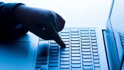 PA Media A child using a laptop computer