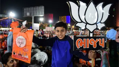AFP A boy holds a Bhartiya Janta Party (BJP) placard during a BJP rally attended by Indian Home Minister Amit Shah ahead of Gujarat assembly elections in Ahmedabad on November 26, 2022.