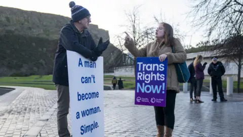 PA Media A member of the Scottish Family Party speaks with a Gender Recognition Reform Bill supporter outside the Scottish Parliament, Edinburgh