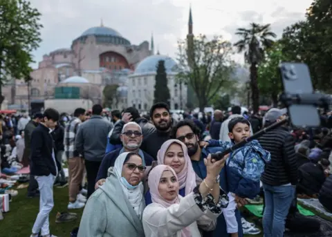 Erdem Sahine /EPA-EFE/ People pose for a selfie
