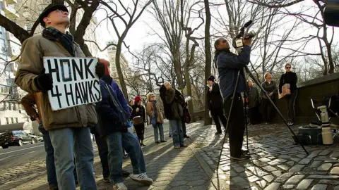 Getty Images Protesters and bird watchers attempt to get a glimpse of Pale Male after his nest was removed in 2004