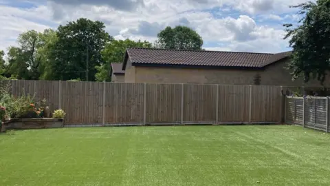 Helen Mulroy/BBC View of the home spa from a neighbouring garden