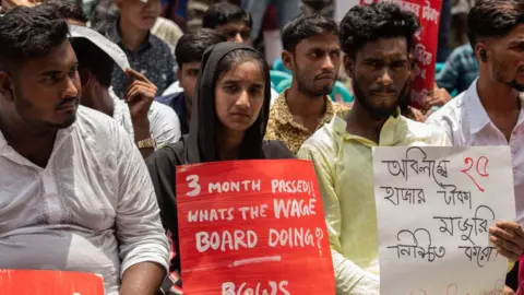 Getty Images Protesters hold placards expressing their opinion during the demonstration. Bangladesh Garment workers gathered to demand an increase in the minimum wage.