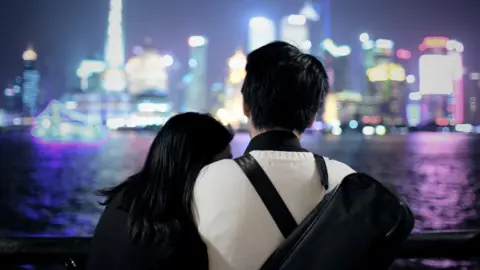 Getty Images A couple look out at a cityscape