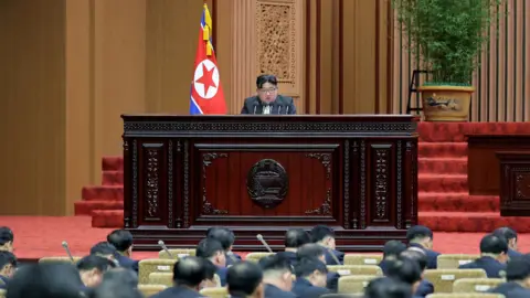 KCNA Kim Jong Un at a lectern addresses the Supreme People's Assembly legislators on 15/1