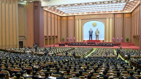 KCNA Kim Jong Un at a lectern addresses the Supreme People's Assembly legislators on 15/1