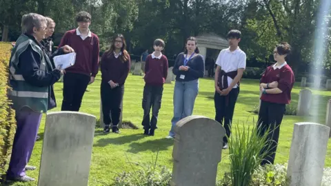 CWGC Group of six children standing beside war graves