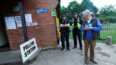 Reuters Police officers stand on duty outside a polling station in Sonning