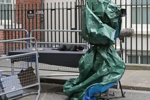 PA Palmerston, the resident Chief Mouser of the Foreign ^ Commonwealth Office (FCO), relaxes on a media stand next to a broadcast camera in Downing Street, London,