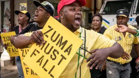 Getty Images Supporters of ANC president Cyril Ramaphosa chant slogans outside party headquarter in Johannesburg, on February 5, 2018